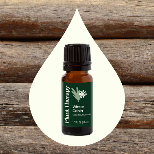 Front of Winter Cabin Essential Oil Blend bottle with wood background